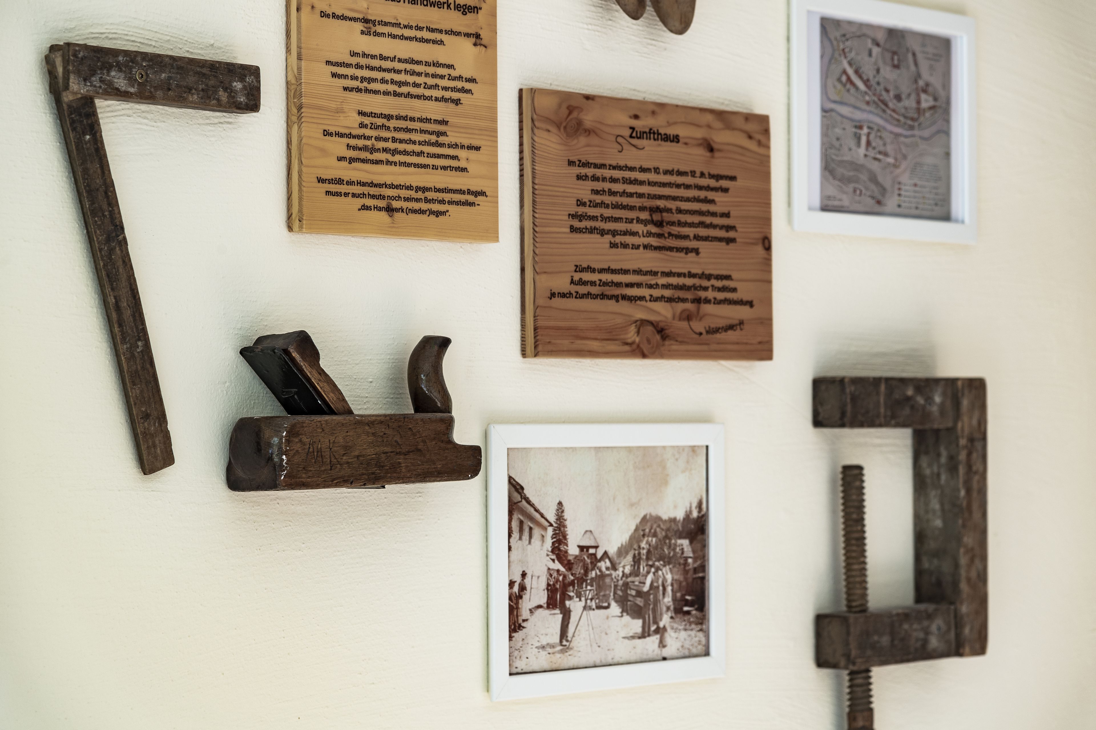 Una pared con herramientas diversas y una fotografía histórica enmarcada.