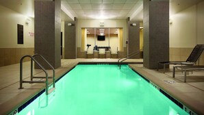 A swimming pool with a tiled border, a lifeguard chair, and a bench. - Hyatt Place Des Moines/Downtown (Des Moines)