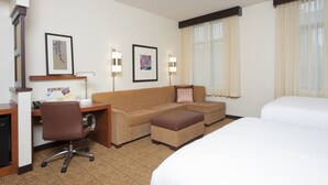 A hotel room with a bed, a sofa, a desk with a chair, and two lamps. - Hyatt Place Des Moines/Downtown (Des Moines)