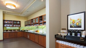A hotel kitchen with wooden cabinets, a buffet counter, and a coffee station. - Hyatt Place Des Moines/Downtown (Des Moines)
