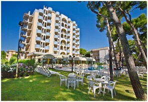 Un hotel con varios balcones, mobiliario exterior y piscina.