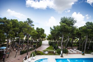 Un resort con piscina, zona de estar al aire libre y área de juegos para niños.