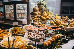 A buffet with various fruits and vegetables displayed on plates. - Canonnier Beachcomber Golf Resort & Spa (Grand-Baie)