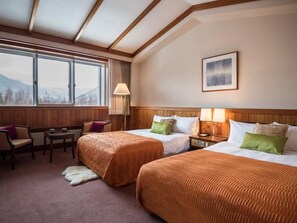 Une chambre d’hôtel avec deux lits, un bureau et une chaise.