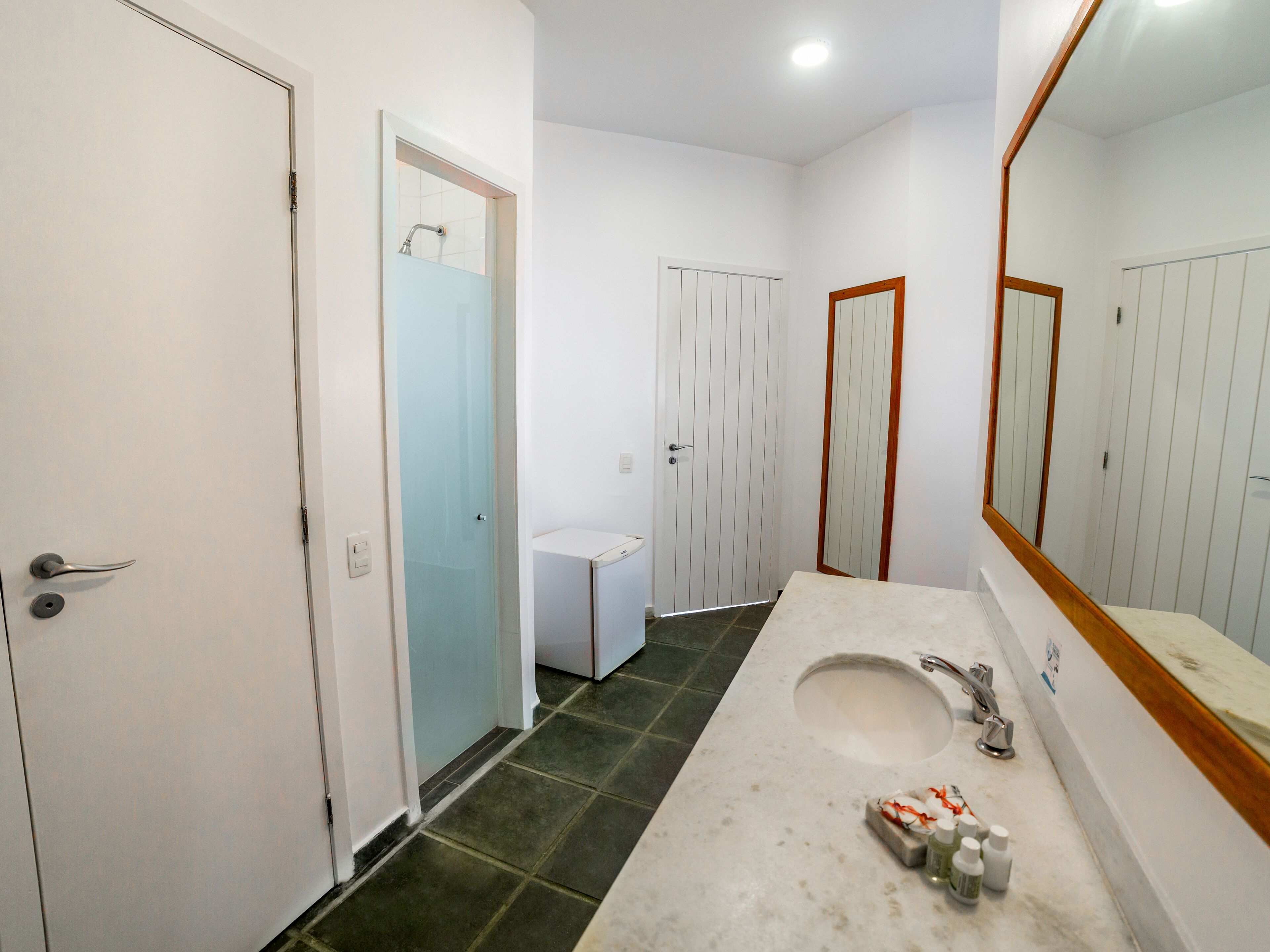 Un bany amb un lavabo, un mirall i dues portes.