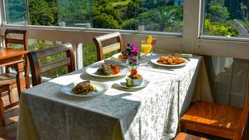 A table set for dining with a view of a lush landscape.