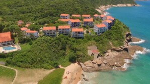 A coastal resort with multiple buildings, a swimming pool, and a beach. - Apa Pau Brasil (Búzios)
