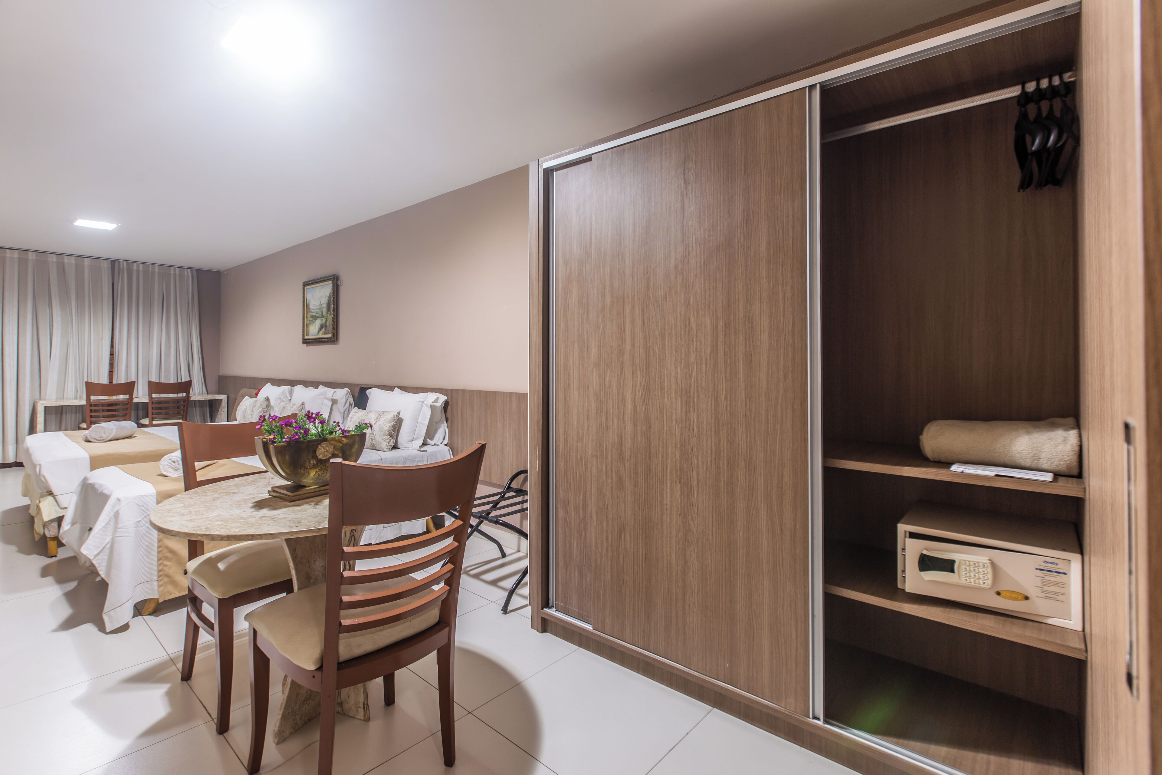 Ein Hotelzimmer mit Essbereich, großem Kleiderschrank und Mikrowelle.