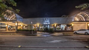 A hotel with a modern design, featuring a prominent logo and a large glass facade. - Amuarama Hotel (Fortaleza)