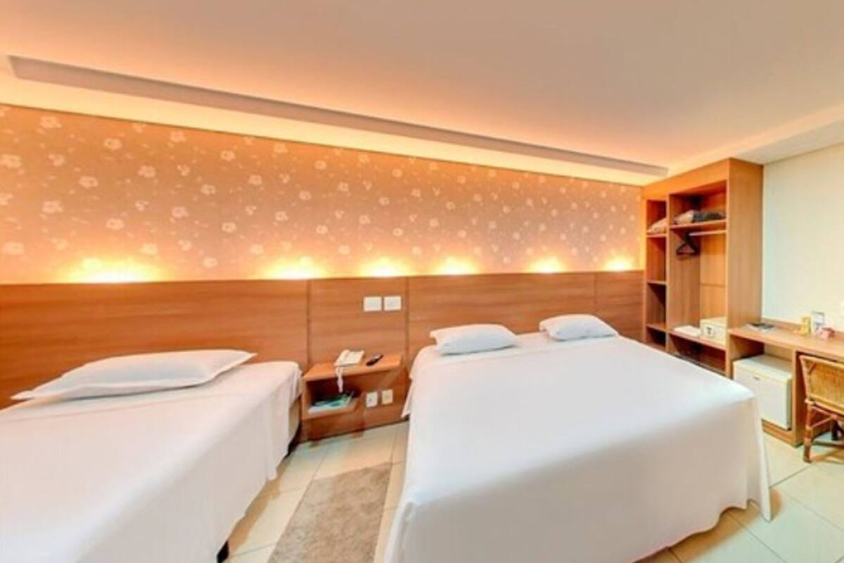 Une chambre d’hôtel avec deux lits, un bureau et une armoire.