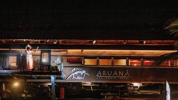 Ein stehender Zug mit der Beschriftung Aruana Eco, Praia Hotel, einem Speisewagen und einem Bahnsteig, auf dem sich eine Person befindet.