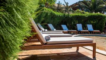A poolside area with lounge chairs and a stone-tiled deck.