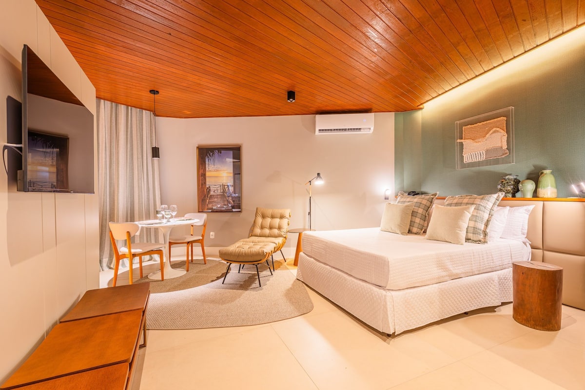 A modern bedroom with a wooden ceiling, a bed, a desk, and a chair.