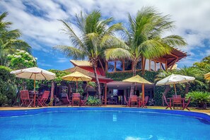 Relax by the pool surrounded by lush tropical vegetation and comfortable lounge chairs.