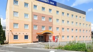 A Comfort Inn hotel with a large sign, multiple windows, and a Coca-Cola vending machine. - Comfort Inn Suwa Inter (Suwa)
