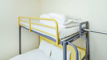 A bunk bed with a yellow frame and white bedding.