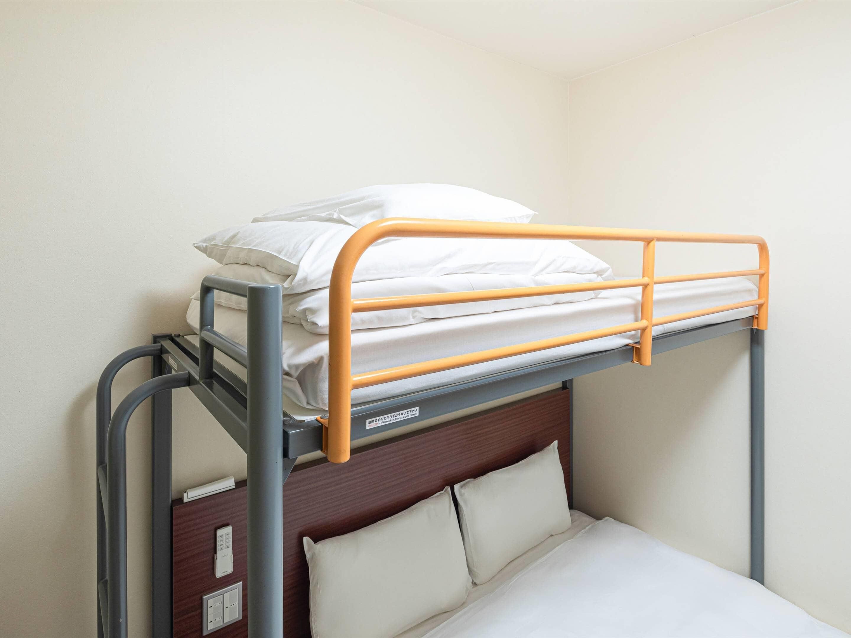 A bunk bed with a wooden headboard and a metal ladder.