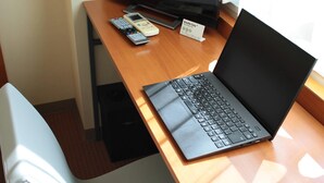 Cubrecamas, escritorio y espacio para trabajar con laptop 