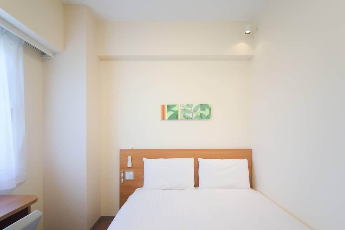 Cubrecamas, escritorio y espacio para trabajar con laptop