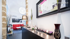 Un interior moderno con un mostrador de recepción negro, un sofá rojo y un marco de fotos colgado en la pared.