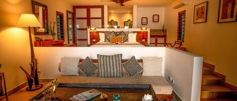 A hotel room with a bed, a sofa, a coffee table, and a staircase.