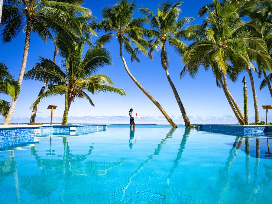 Una piscina al aire libre, sombrillas, sillones reclinables de piscina