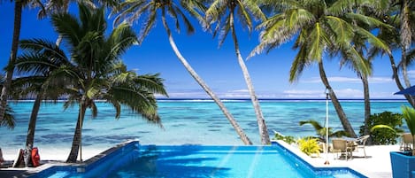 Een buitenzwembad, parasols bij het zwembad en ligstoelen