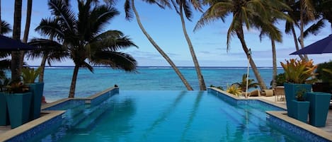 Una piscina al aire libre, sombrillas, tumbonas