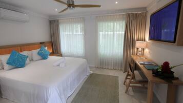 A hotel room with a bed, a desk, a television, and curtains.