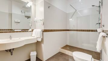 Ein modernes Badezimmer mit Waschbecken, Spiegel, Dusche und Toilette.