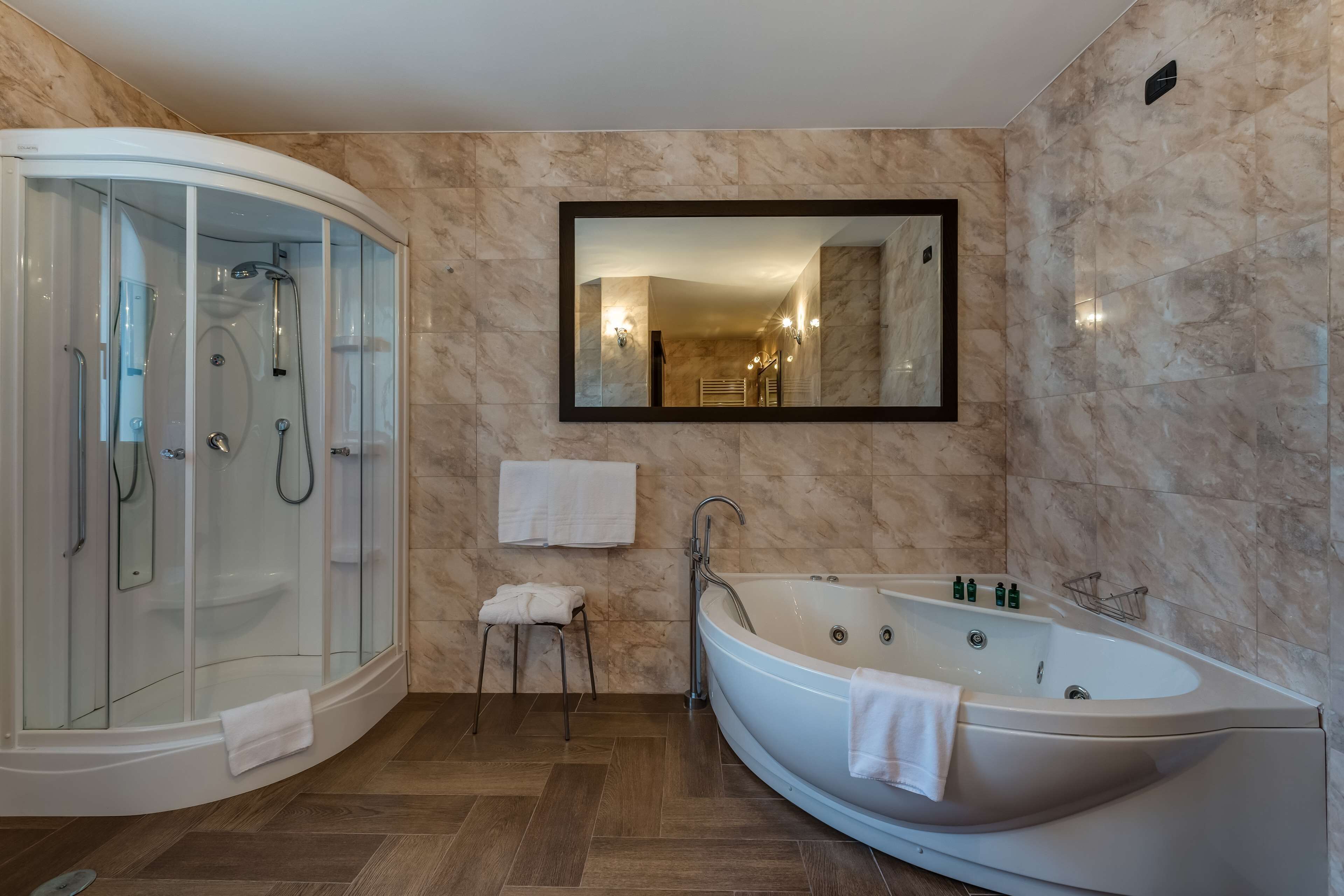 Ein modernes Badezimmer mit einer einteiligen Duschkabine, einer freistehenden Badewanne und einem großen Spiegel.