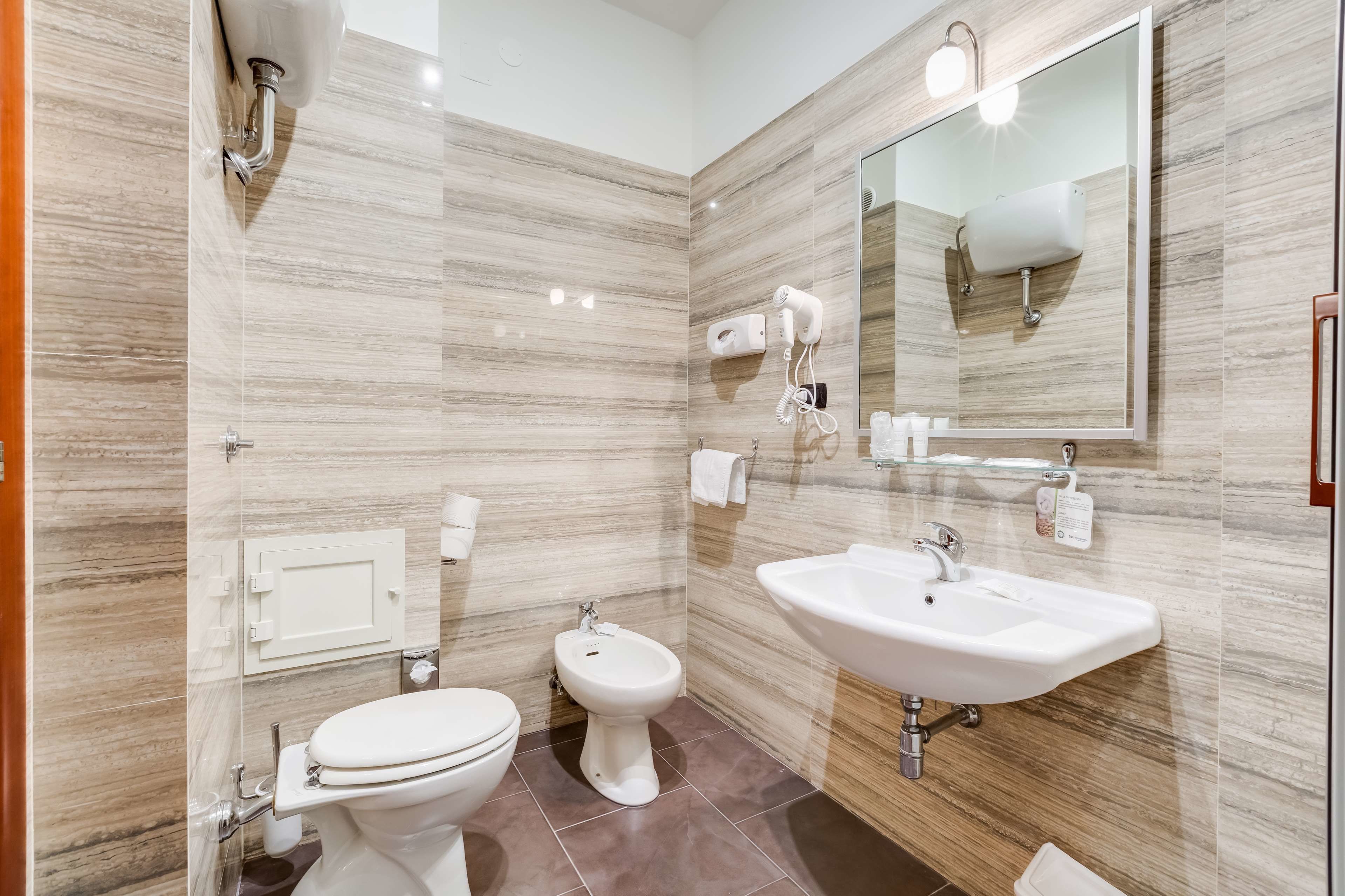 A modern bathroom with a toilet, bidet, and sink.