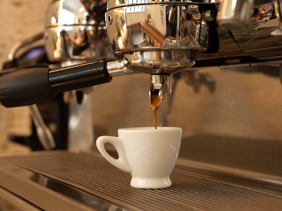 A coffee machine dispensing coffee into a white cup.