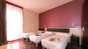 A hotel room with two beds, a small table with breakfast items, and a nightstand with a clock. - Hotel Five (Milan)