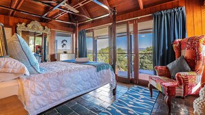 A spacious bedroom with a large bed, a chair, and a view of the outdoors. - 1770 Sovereign Lodge Resort (Seventeen Seventy)
