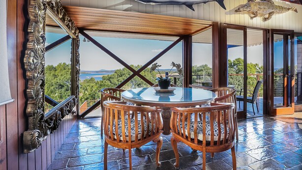 A dining area with a round table and chairs, a view of the outdoors, and decorative fish mounted on the ceiling. - 1770 Sovereign Lodge Resort (Seventeen Seventy)