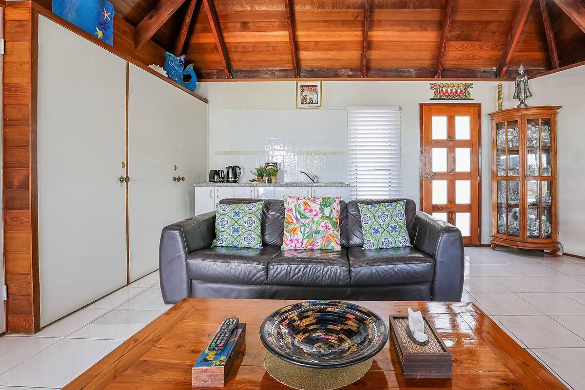 A living room with a leather sofa, a wooden coffee table, and a cabinet with glass doors.