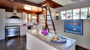 A kitchen with a central island, stainless steel appliances, and a large window with stained glass. - 1770 Sovereign Lodge Resort (Seventeen Seventy)