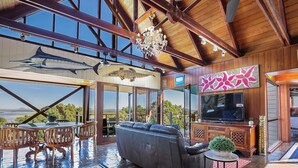 A spacious living area with a large leather sofa, wooden dining set, and a television. - 1770 Sovereign Lodge Resort (Seventeen Seventy)