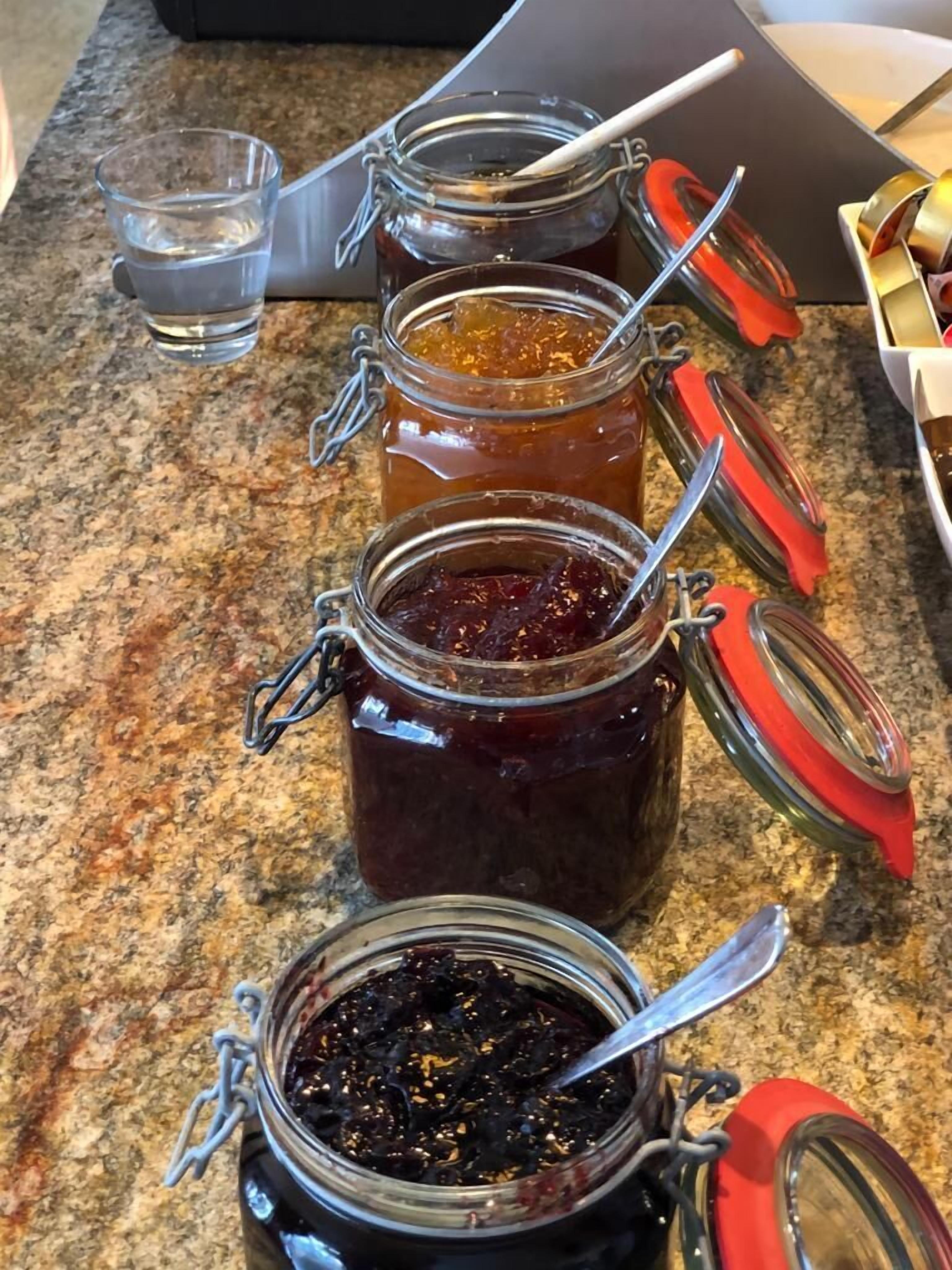 Three glass jars with metal lids and handles on a granite countertop.