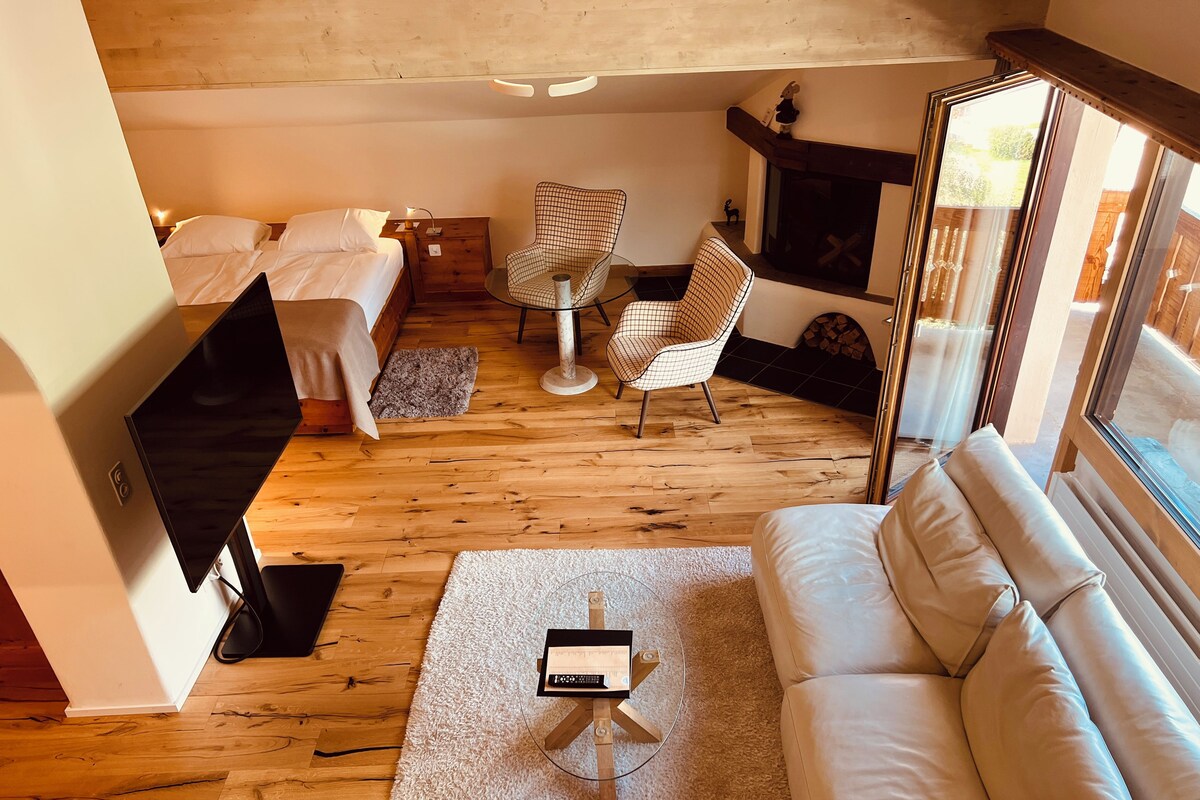 Een gezellige woonkamer met een bank, een salontafel, een televisie en een open haard.