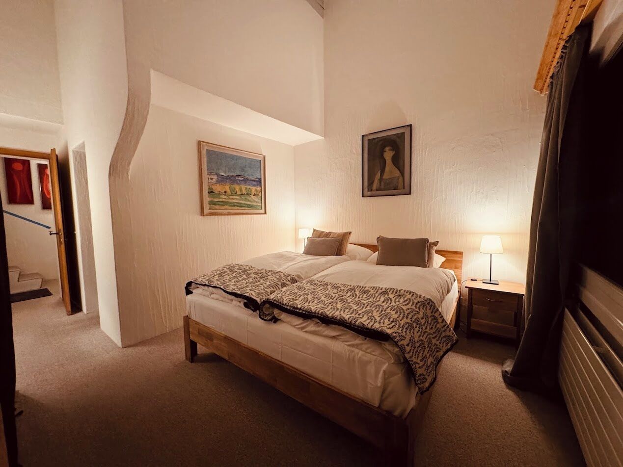 Un dormitorio con una cama grande, dos mesitas de noche y un cuadro en la pared.