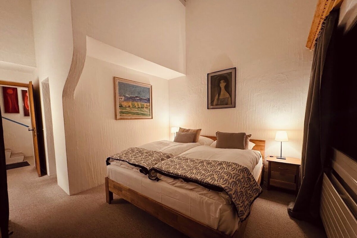 Un dormitorio con una cama grande, dos mesitas de noche y un cuadro en la pared.