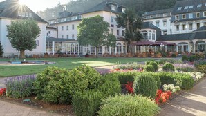 A hotel with a garden, outdoor seating, and a fountain. - Hotel Fürstenhof Bad Bertrich (Bad Bertrich)