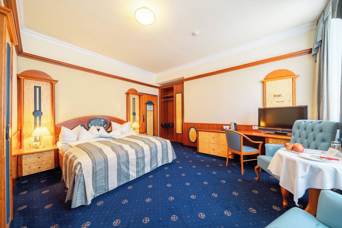 Ein Hotelzimmer mit Bett, Schreibtisch, Fernseher und Sitzecke.