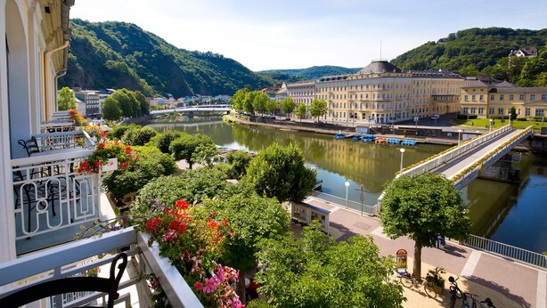 A riverside view with a bridge, buildings, and greenery. - Häcker's Grand Hotel Bad Ems (Bad Ems)