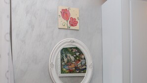 A small, white table with a black chair, a white cabinet, and a framed picture of a cityscape on the wall. - Residenza Nicola Amore (Naples)