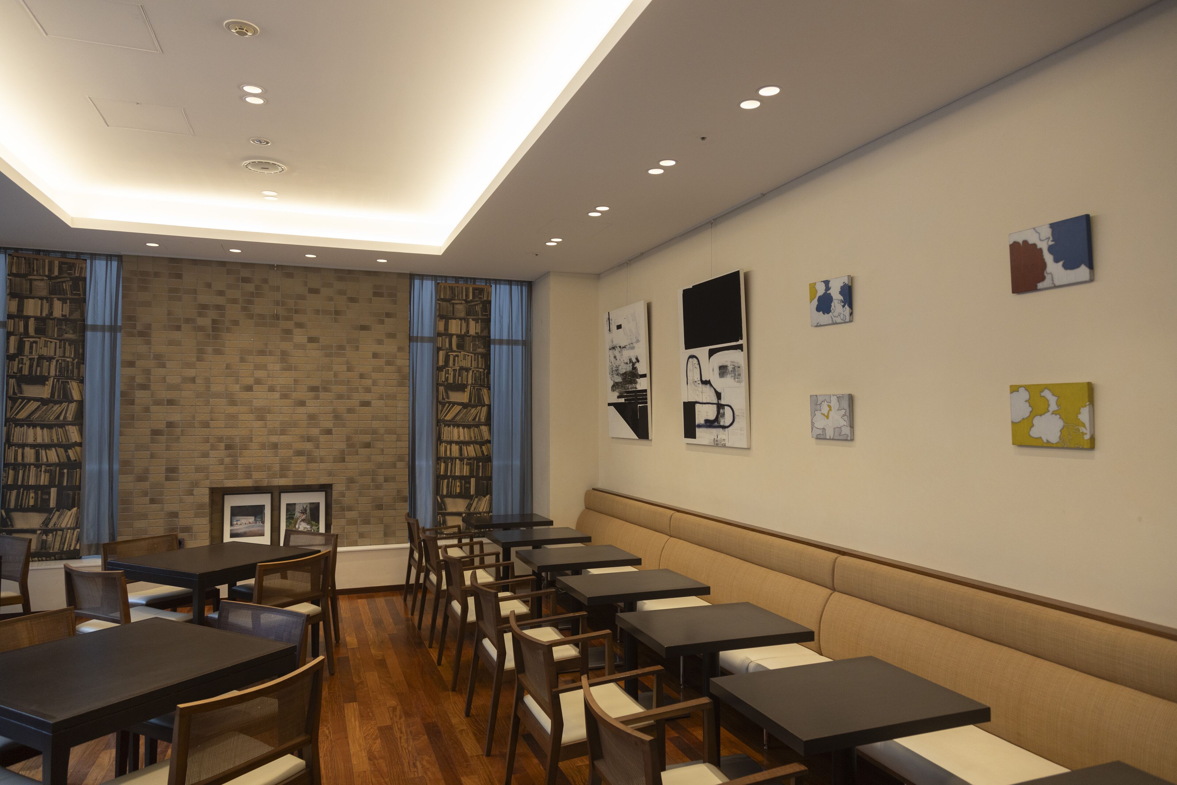 A modern library with bookshelves, tables, and a seating area.