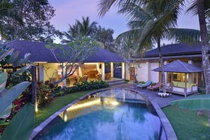 Un resort con piscina, asientos al aire libre y un área techada.