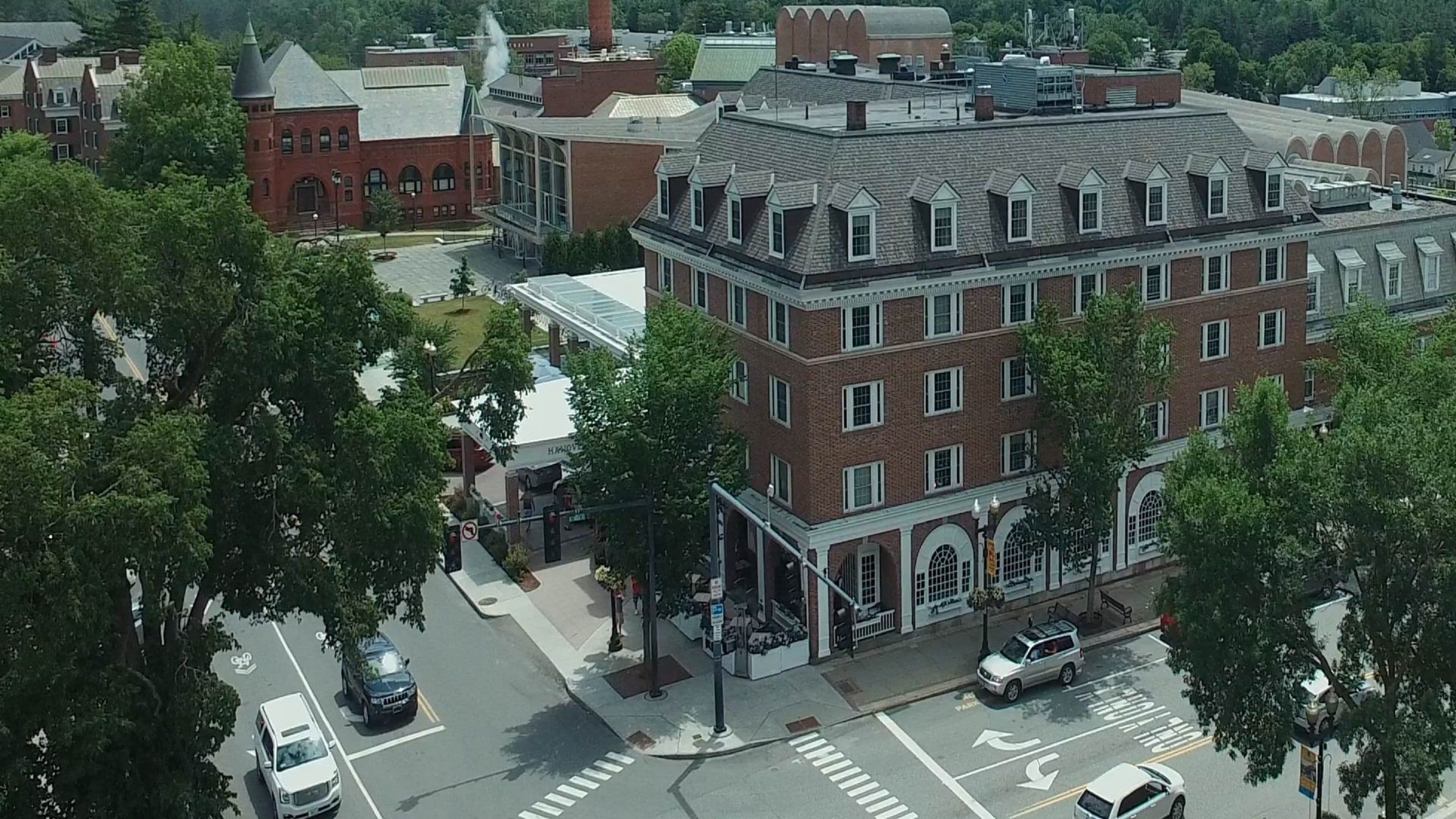 A multi-story building with a brick facade, large windows, and a corner entrance.